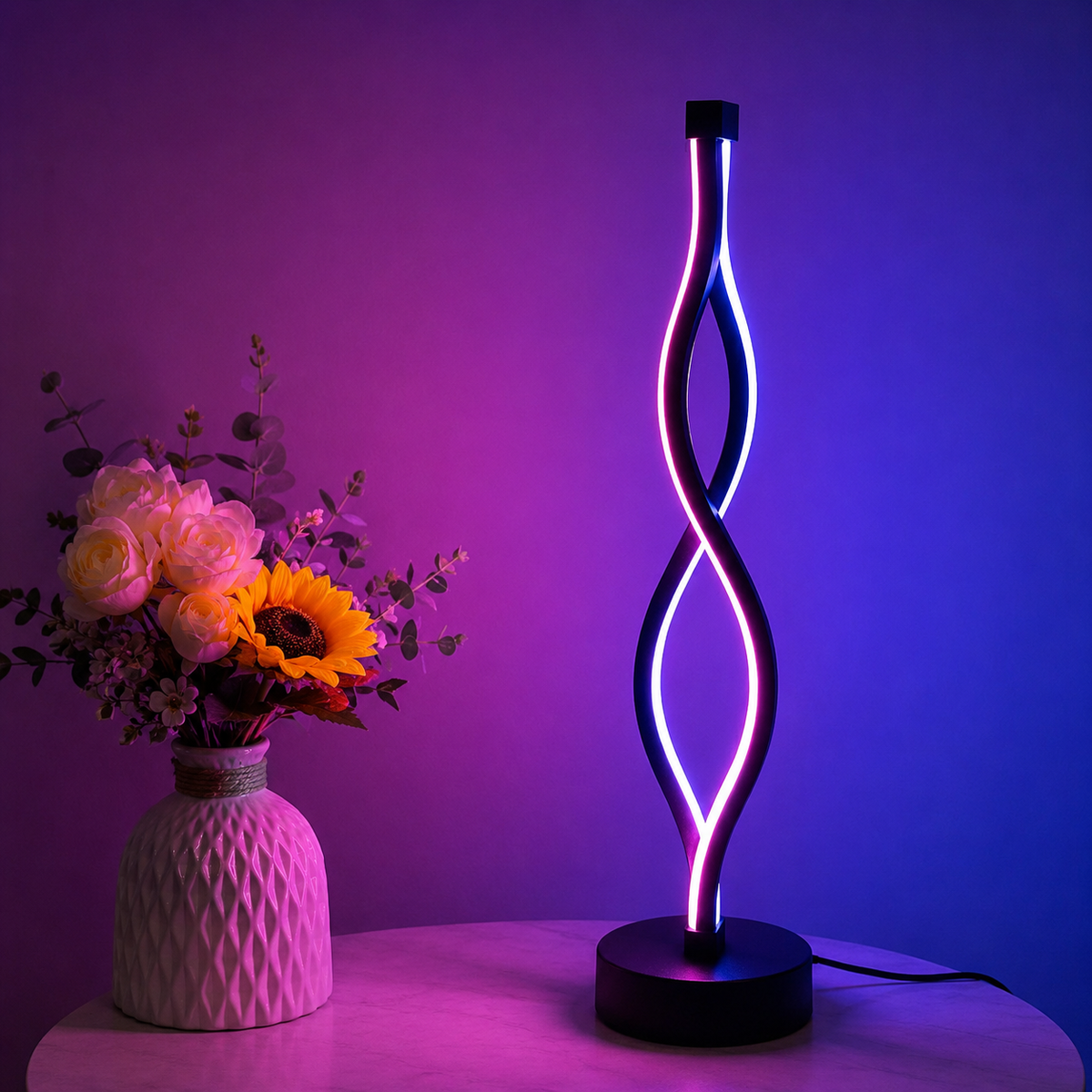 Ribbon Table Lamp lit in pink and purple beside flowers