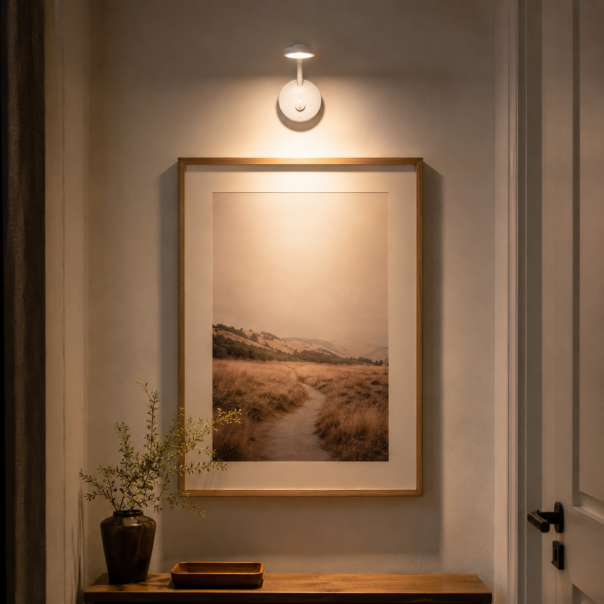 Motion Sensor Wall Light lit above a framed landscape print