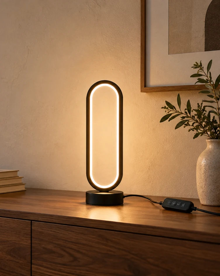 Ring Table Lamp glowing on a walnut console beside its inline controller